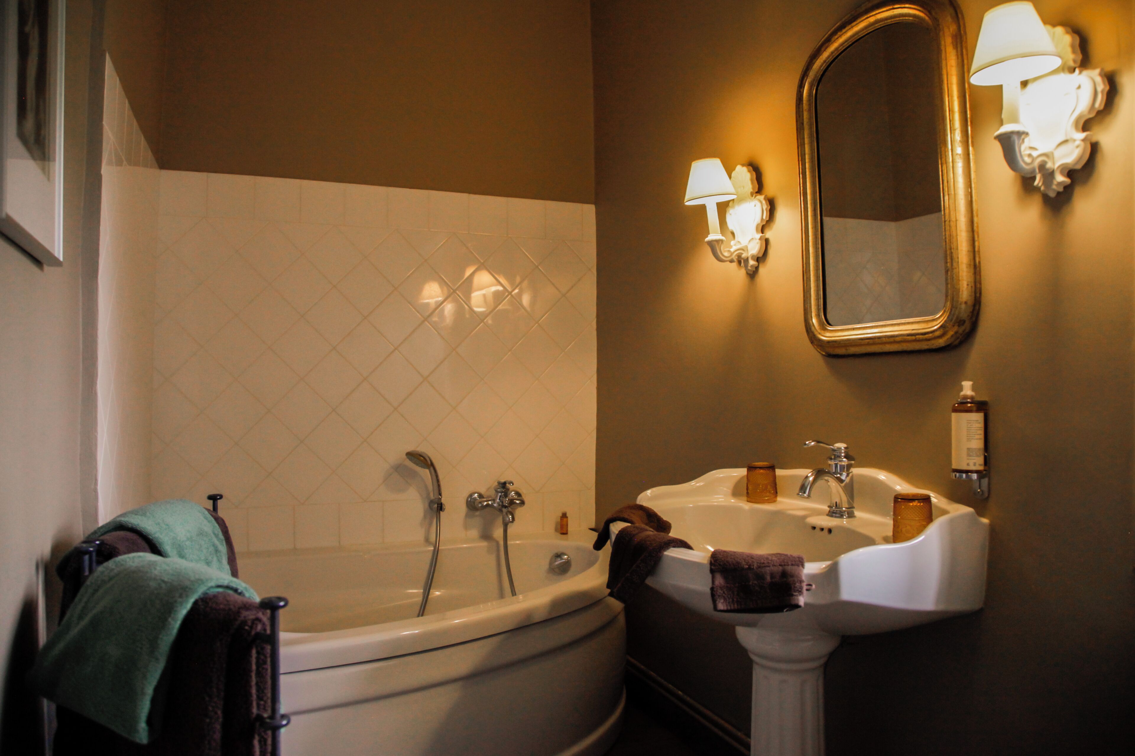A bathroom with a bathtub, a sink, and a mirror.