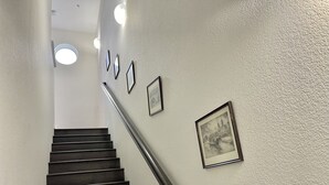 A staircase with a handrail, a textured wall, and three framed pictures. - Newly Remodeled Townhouse Communication Hill (San Jose)