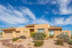 A modern house with a flat roof, large windows, and a desert garden with rocks and cacti. - Desert Oasis ★Pool-Spa-Disc Golf-Ping Pong-Poker Table-Pool Table★ (Scottsdale)