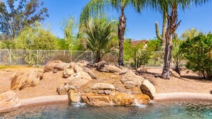 A clear pool with a rocky edge and a waterfall feature. - Desert Oasis ★Pool-Spa-Disc Golf-Ping Pong-Poker Table-Pool Table★ (Scottsdale)