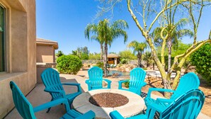 A patio with turquoise chairs and a stone fire pit. - Desert Oasis ★Pool-Spa-Disc Golf-Ping Pong-Poker Table-Pool Table★ (Scottsdale)