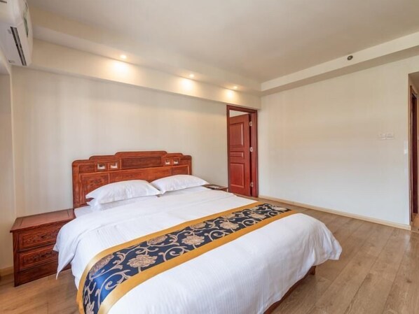 A bedroom with a wooden bed, a nightstand, and a door.