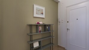 Ein Flur mit einem grauen Bücherregal, einem gerahmten Bild an der Wand und einer weißen Tür.