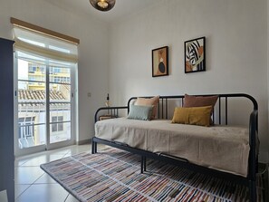 A bedroom with a bed, a window, and two wall-mounted artworks. - Modern family home  (Faro)