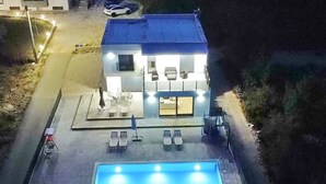 Un bâtiment moderne doté d’une piscine, d’un espace extérieur aménagé et d’un patio couvert.