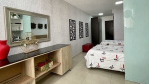 Ein Schlafzimmer mit Bett, Kommode, Spiegel und Kleiderschrank.