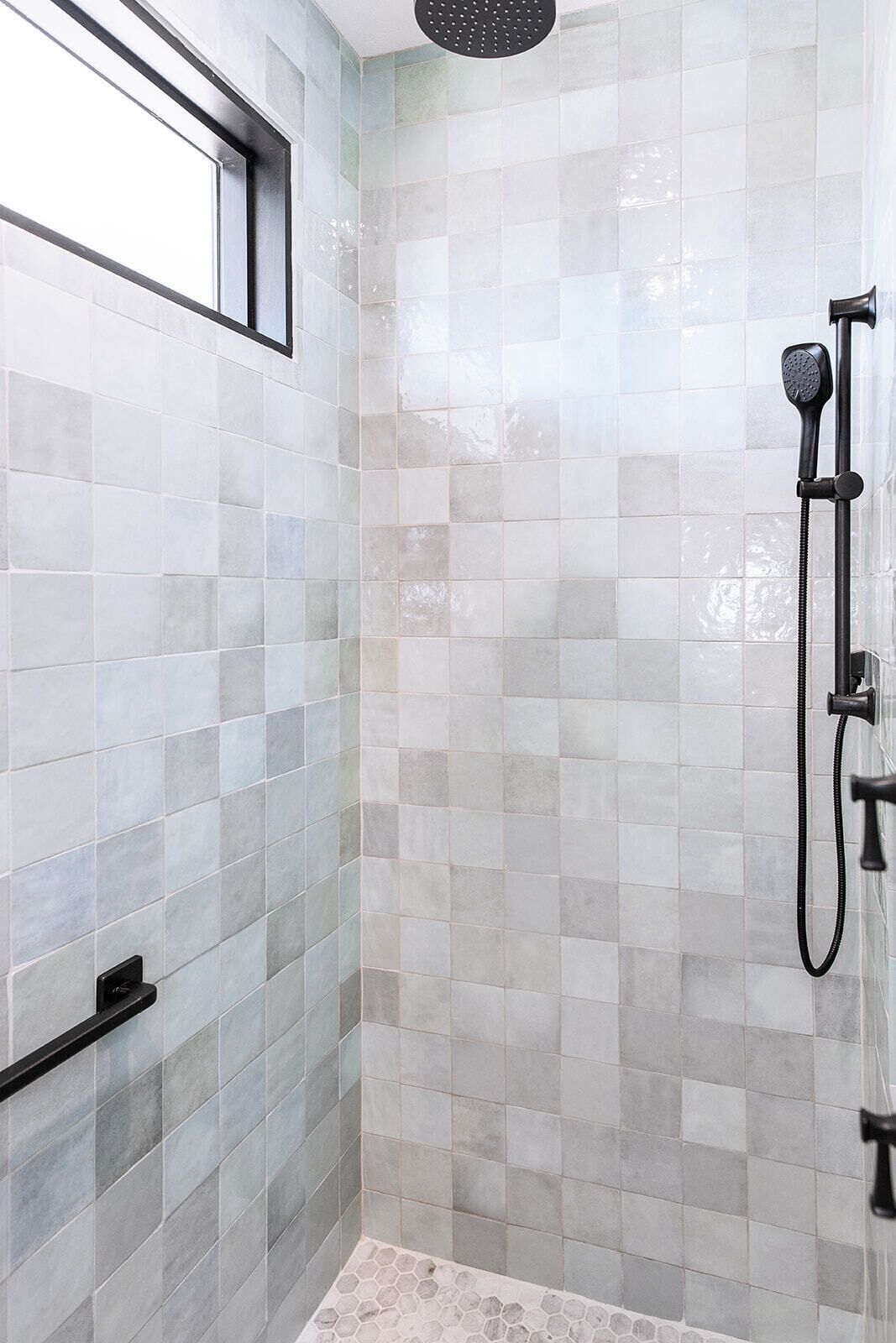 A shower area with tiled walls and a window.