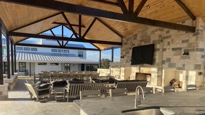 An outdoor patio with stone walls, a stone fireplace, and multiple seating areas. - Lone Star River Ranch- Large Luxury Venue for Conferences & Retreats - sleeps 44 (Brady)