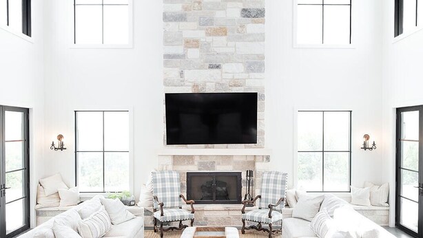 A spacious living room with a stone fireplace, white sofas, and a large TV mounted on the wall. - Lone Star River Ranch- Large Luxury Venue for Conferences & Retreats - sleeps 44 (Brady)