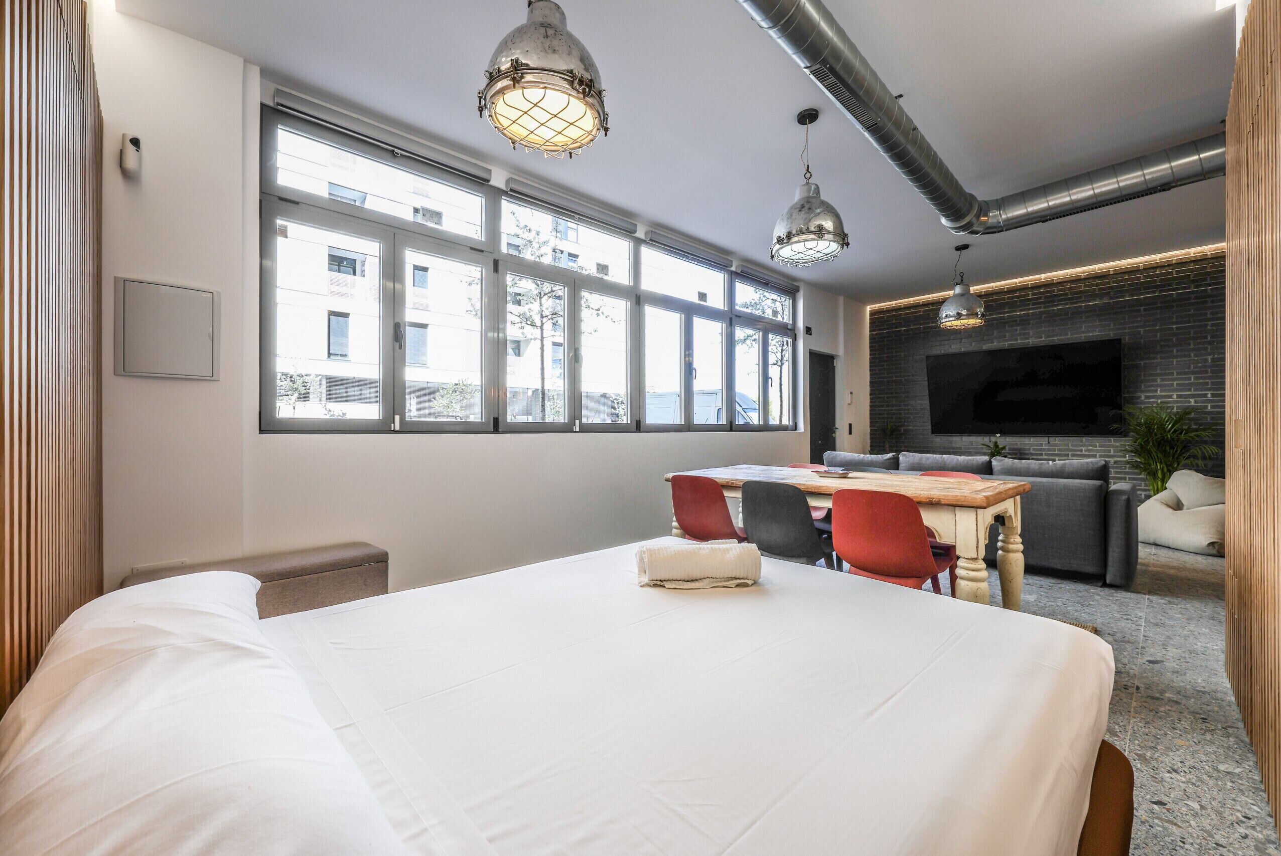 A hotel room with a bed, a desk, a sofa, and a TV.