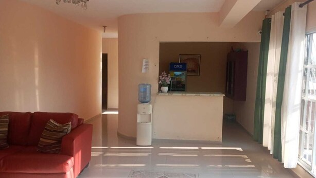 A reception area with a water dispenser, a counter, and a sign that reads "GRS".