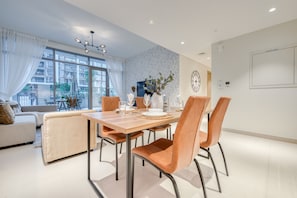 Un coin repas moderne avec une table en bois, quatre chaises et un vase rempli de fleurs.