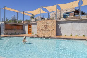 Een buitenzwembad en ligstoelen