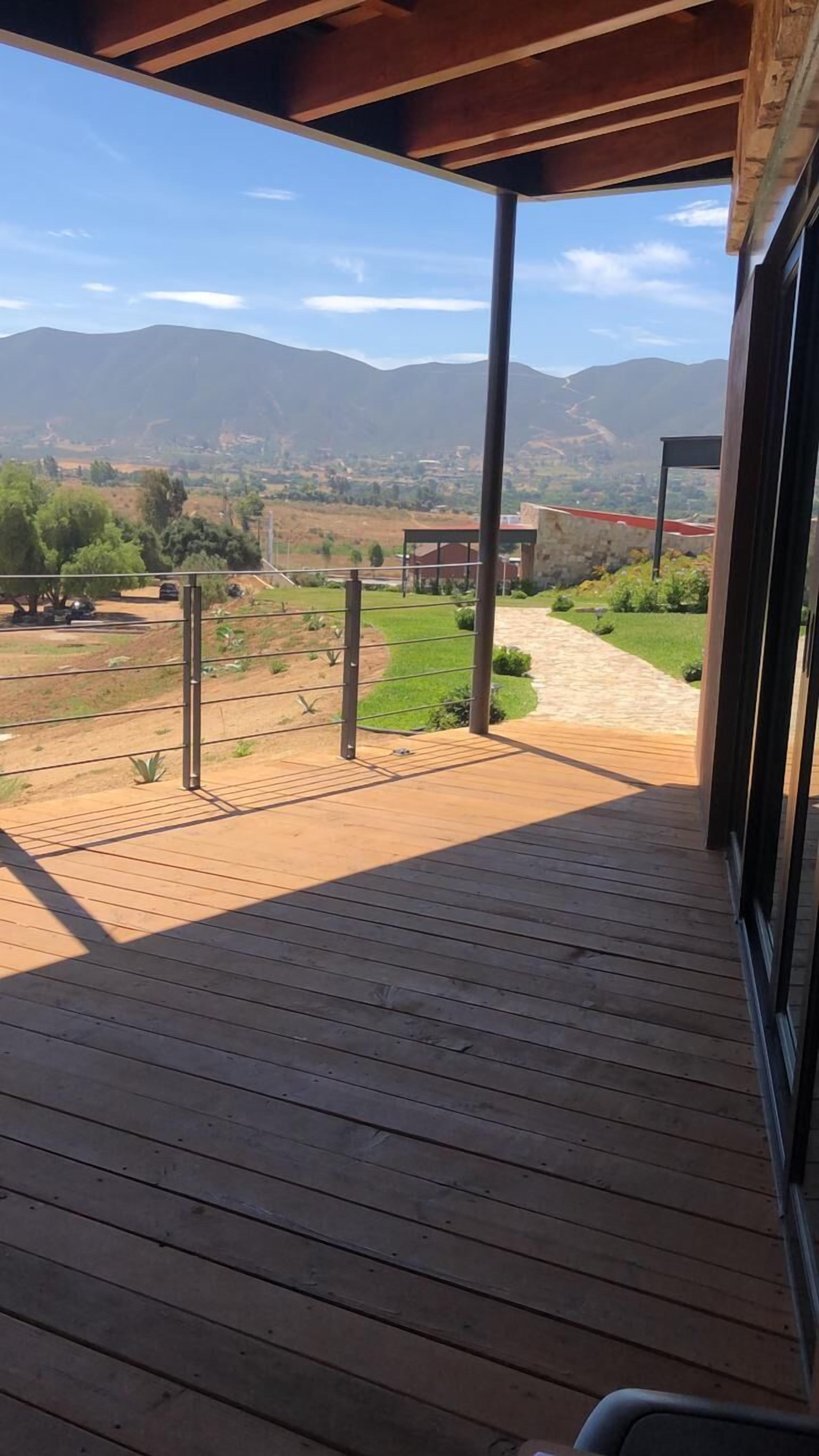 A wooden deck with a view of a mountainous landscape.