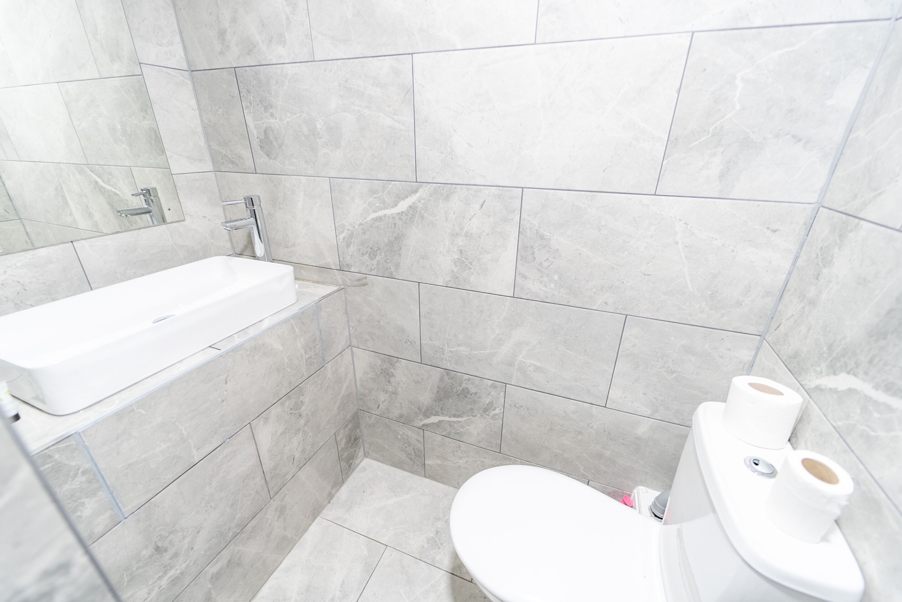 A bathroom with a white bathtub, a toilet, and a shower area.
