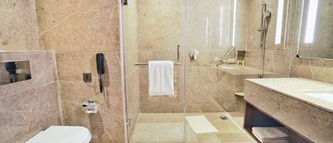 A modern bathroom with a glass-enclosed shower, a toilet, a sink, and a vanity with a mirror.