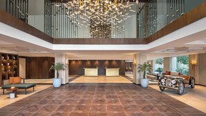 A spacious lobby with a reception desk, seating area, and a classic car display. - Hyatt Centric Rajpur Road Dehradun (Dehradun)