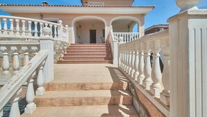 Eine prachtvolle Treppe führt zu einem Gebäude mit einem Ziegeldach und einem Balkon mit weißen Brüstungen.