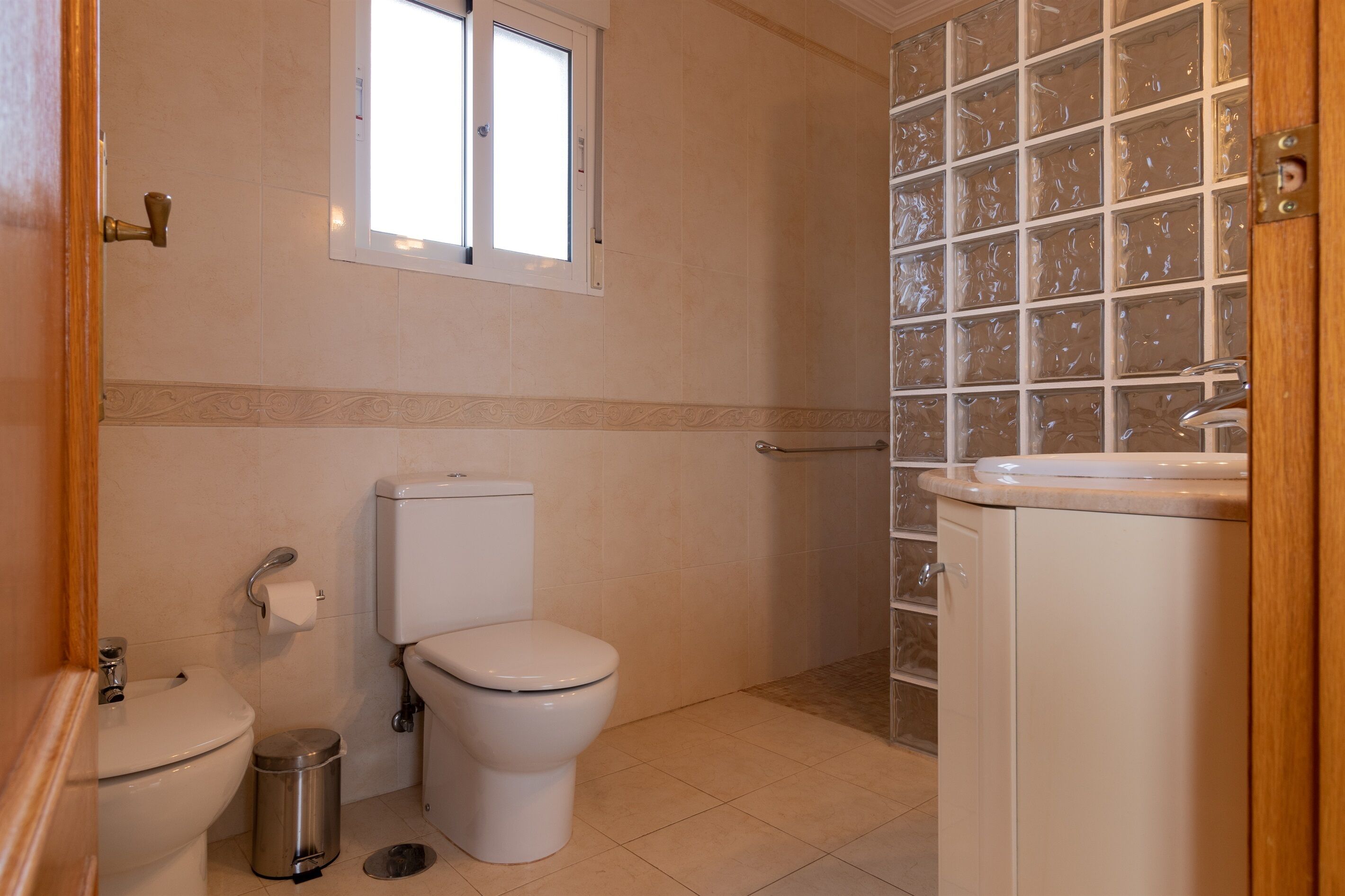 A bathroom with a toilet, bidet, and sink.