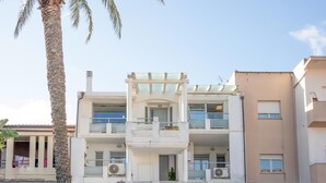 Un immeuble moderne à deux étages, doté de balcons, de grandes fenêtres et de climatiseurs.