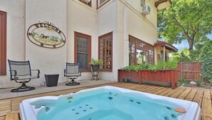 A backyard with a hot tub, outdoor seating, and a 'Welcome Friends' sign. - Queen Size Suite with a shared Hallway Bath (Gainesville)
