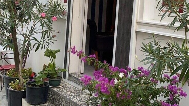A building entrance with potted plants and flowers. - Mazi Otel (Mudanya)