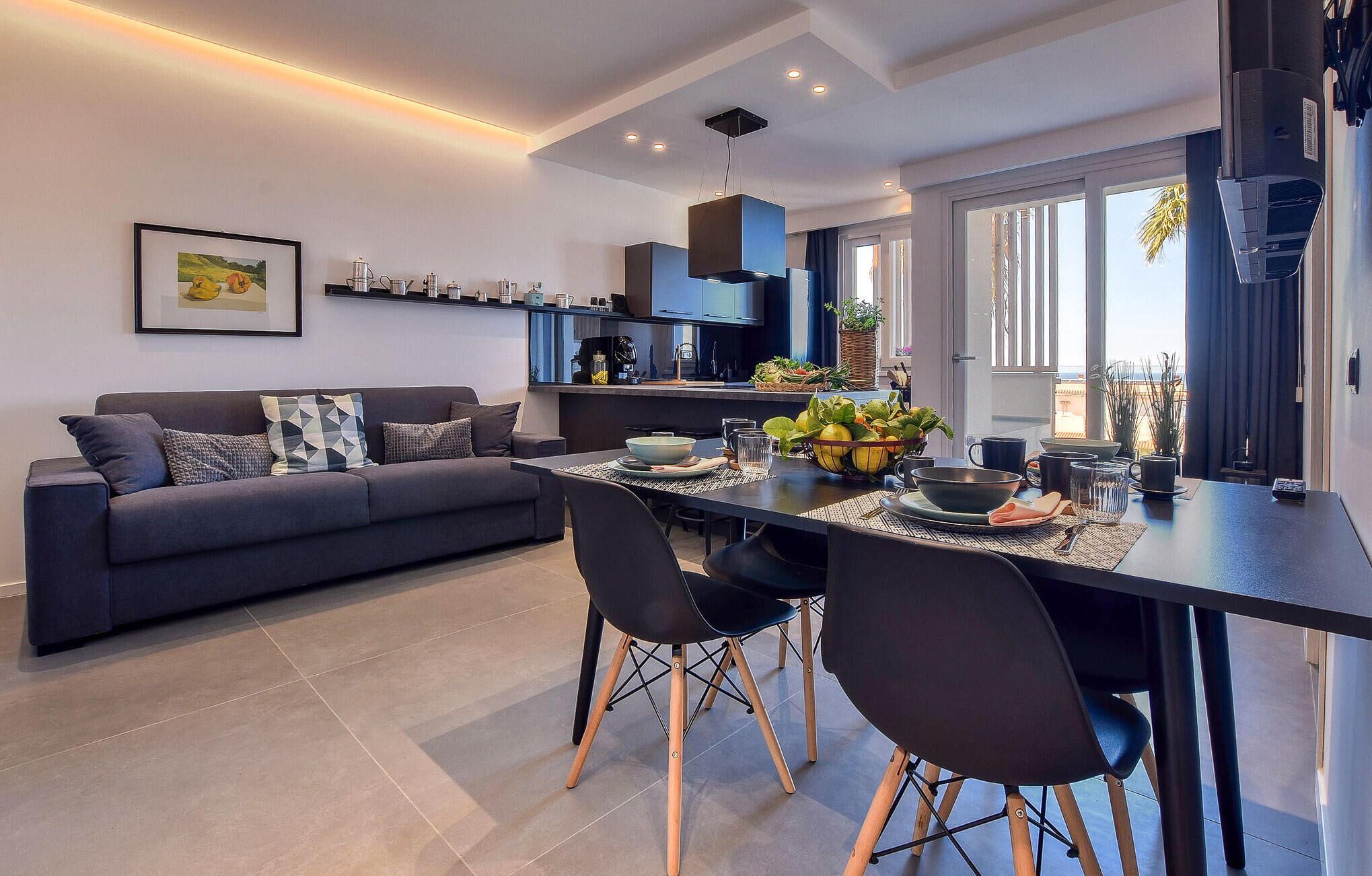Une cuisine moderne avec un coin repas, comprenant un canapé, des chaises et une table dressée pour le dîner.