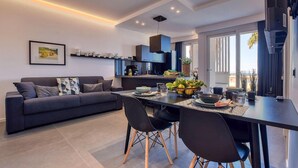 A modern kitchen with a dining area, featuring a sofa, chairs, and a table set for dining. - 2 bedroom amazing apartment in Trappeto (Trappeto)