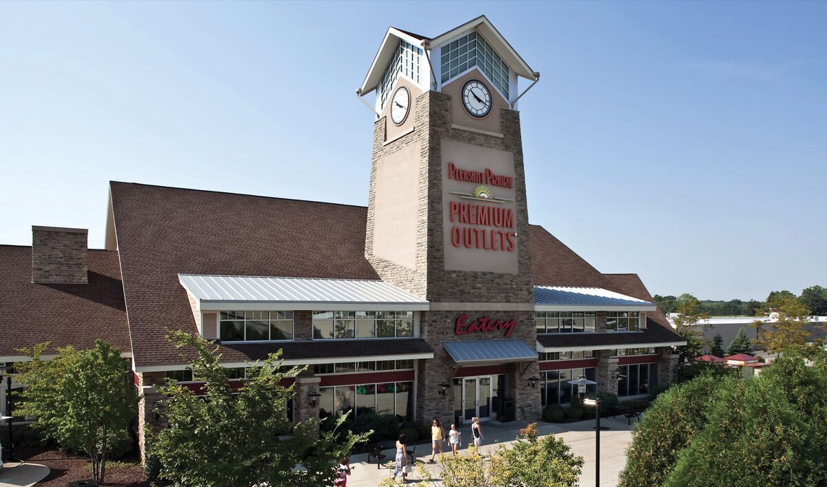 A building with a clock tower, a sign for 'Premium Outlets', and a 'Catering' sign.