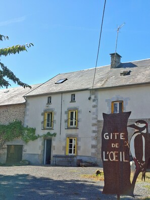 A building with a sign reading 'GITE DE L'OIEL' and a bird sculpture.