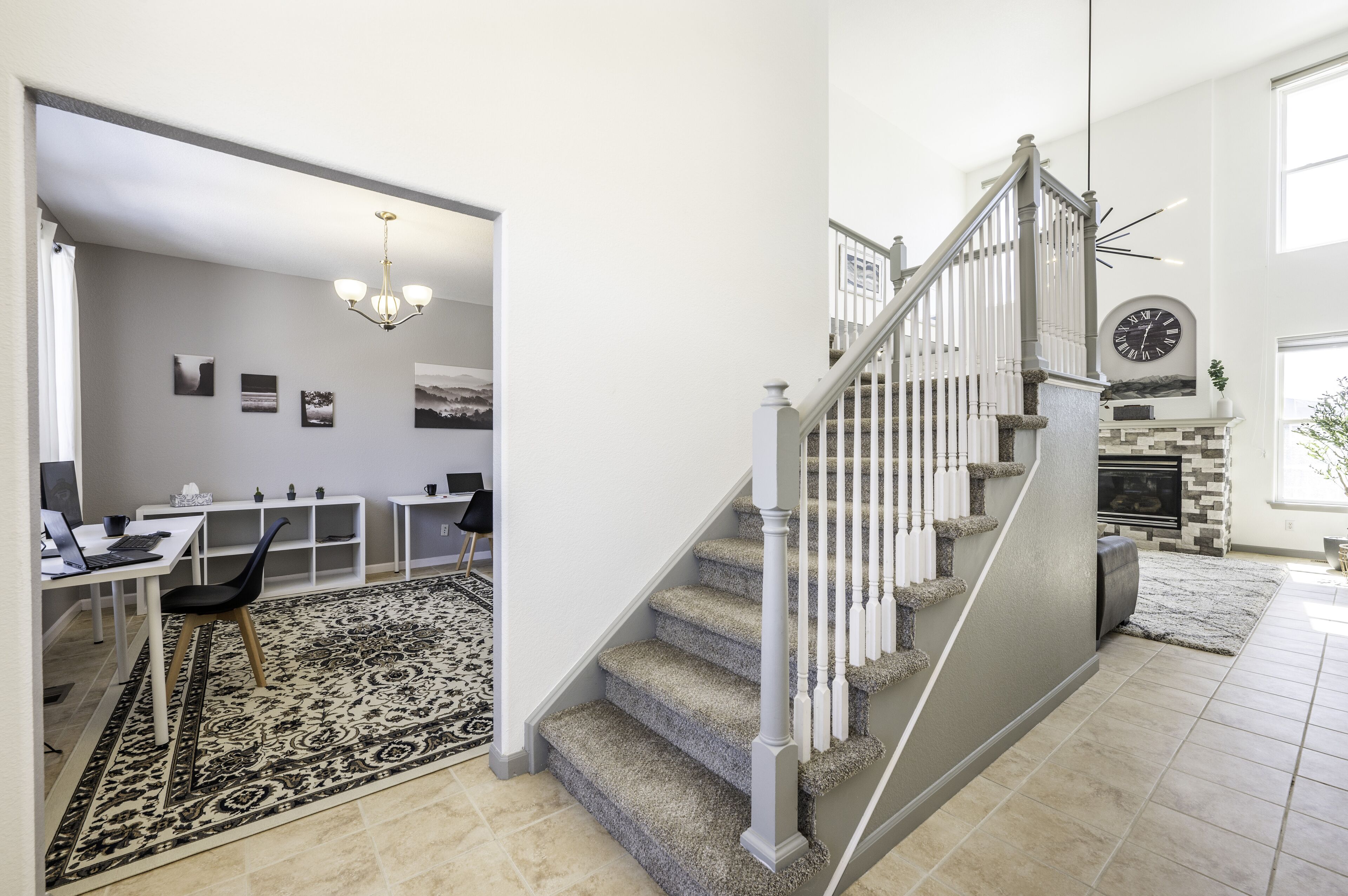 Ein modernes Wohnzimmer mit Treppe, Essbereich und Kamin.