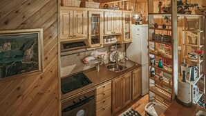 Un interior de madera con cocina, que incluye armarios, una estufa y un refrigerador.