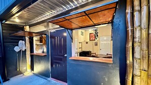 Een gebouw met een donkere gevel, een houten deur en een klein raam.