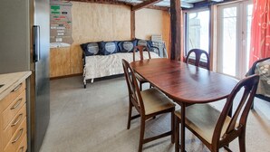 A compact room with a wooden dining table, chairs, a bed with Scandinavian-themed pillows, and a wooden cabinet. - Nice apartment in Vedum with WiFi (Vedum)