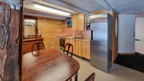 A compact kitchen with wooden cabinets, a stainless steel refrigerator, and a dining table with chairs. - Nice apartment in Vedum with WiFi (Vedum)