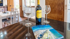 Una botella de vino Rioja Campo Viejo, dos copas de vino y un libro de viajes titulado "To the Sea of Mar" sobre una encimera de cocina.