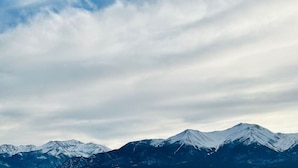 Cordillera montañosa con picos nevados bajo un cielo nublado.
