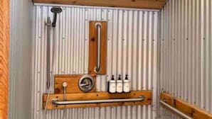 Una sauna con bancos de madera, un perchero para toallas y tres botellas de jabón.