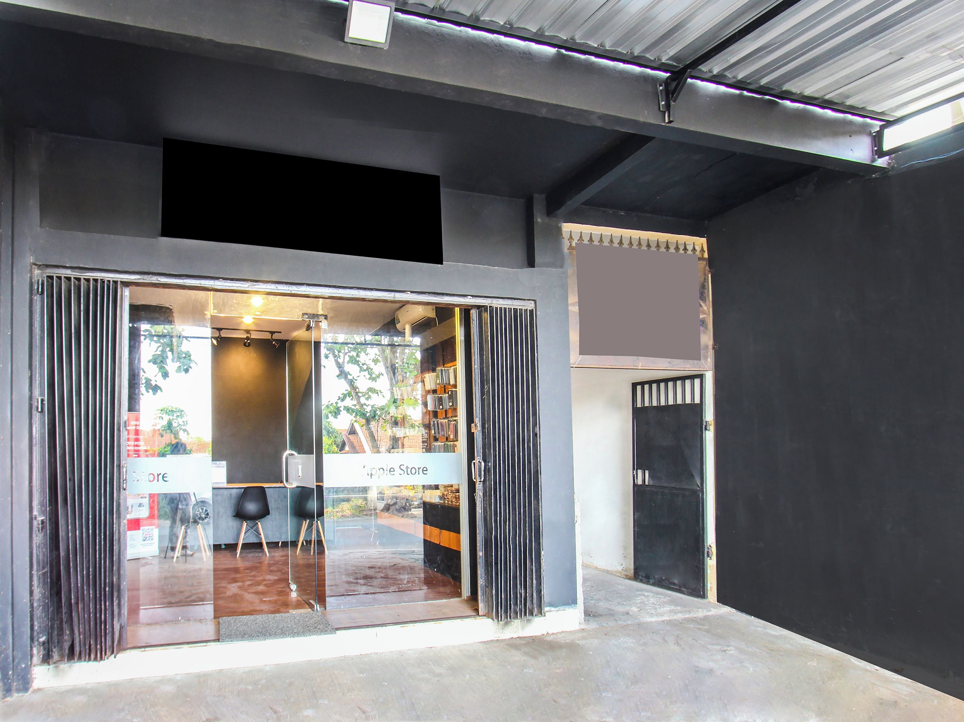 A storefront with a glass entrance, a sign indicating an Apple Store, and a metal door to the right.