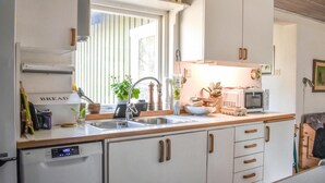 A compact kitchen with a sink, a microwave, and a dish rack. - Stunning home in Borrby with WiFi (Borrby)