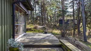 A wooden deck leading to a glass door entrance of a building surrounded by a forest. - Stunning home in Borrby with WiFi (Borrby)