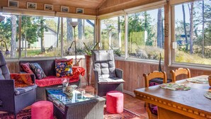A cozy room with wicker furniture, a red ottoman, and a dining table. - Stunning home in Borrby with WiFi (Borrby)