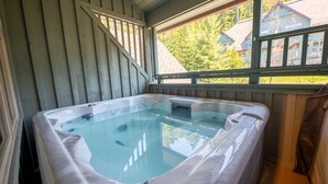 A hot tub in a room with wooden walls and a window. - Modern Ski-in Townhome with Hot Tub (Whistler)