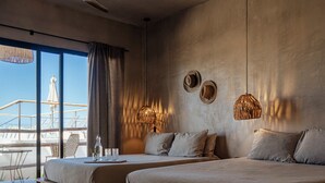 Quarto de hotel moderno com duas camas, uma janela grande com vista e uma varanda.