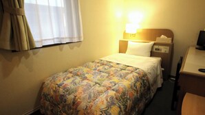 A hotel room with a bed, a nightstand, a desk, and a television. - Business Hotel Toyo (Iwaki)