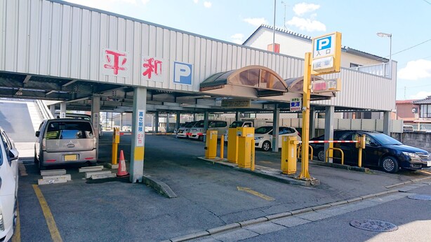 A parking garage entrance with multiple levels, marked with height restriction signs and a parking sign. - Business Hotel Toyo (Iwaki)