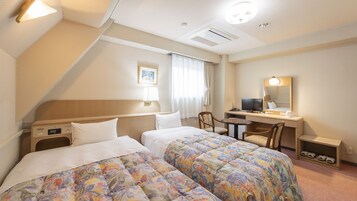 Una habitación de hotel con dos camas, un escritorio, una silla, un televisor y un espejo.