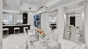 A modern kitchen with white cabinets, a central island, and pendant lighting. - Fort Lauderdale Luxury Condo (Fort Lauderdale)