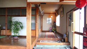 Ein traditionelles japanisches Interieur mit Tatami-Böden, einer Holztreppe und einem roten Laternen.