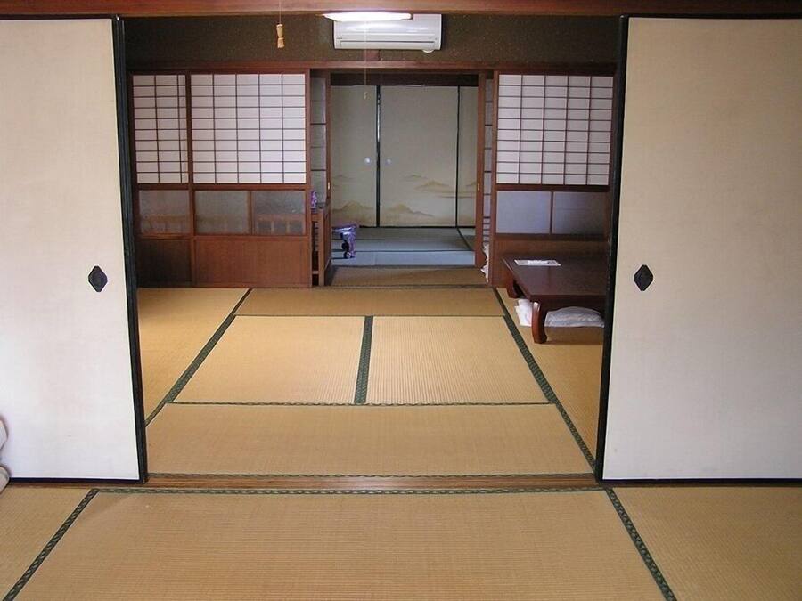 Una habitació japonesa tradicional amb terra de tatami, portes corredisses i una taula baixa.